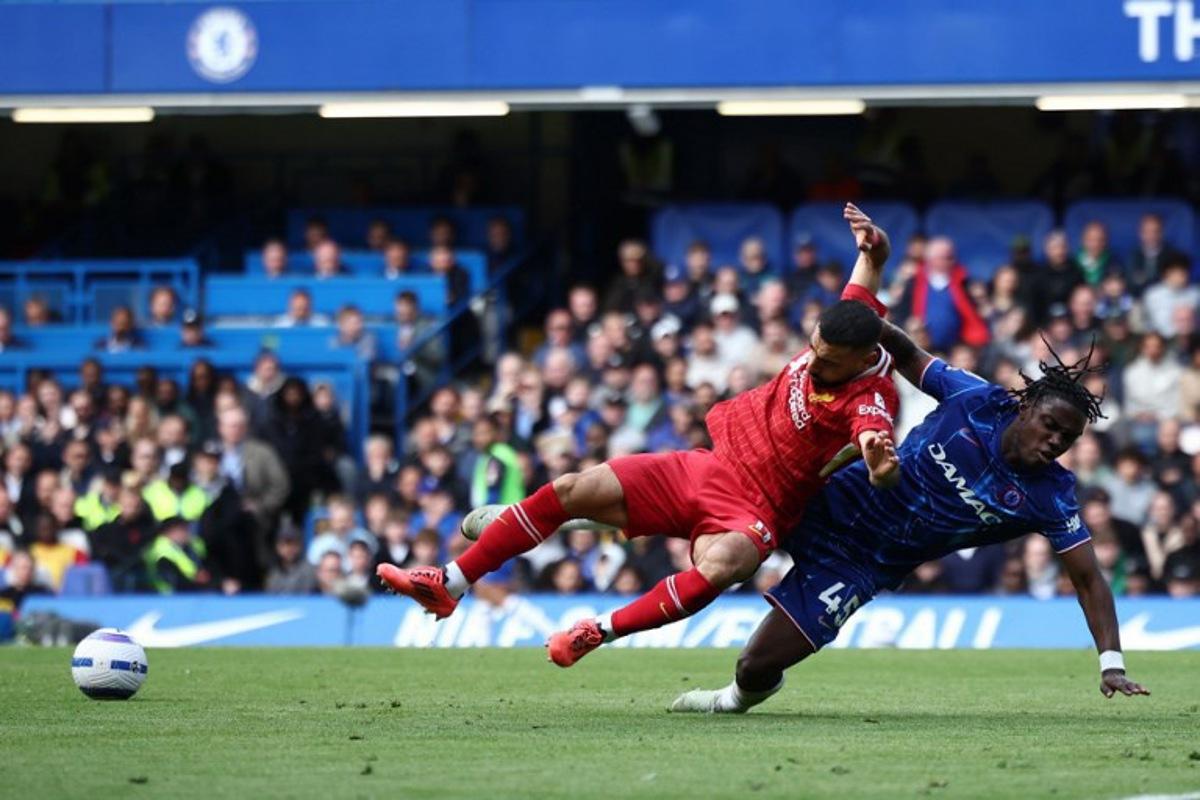 Liverpool's Egyptian striker #11 Mohamed Salah (C) is fouled by Chelsea's Belgian midfielder #45 Romeo Lavia (R) during the English Premier League football match between Chelsea and Liverpool at Stamford Bridge in London on May 4, 2025.  HENRY NICHOLLS / AFP
