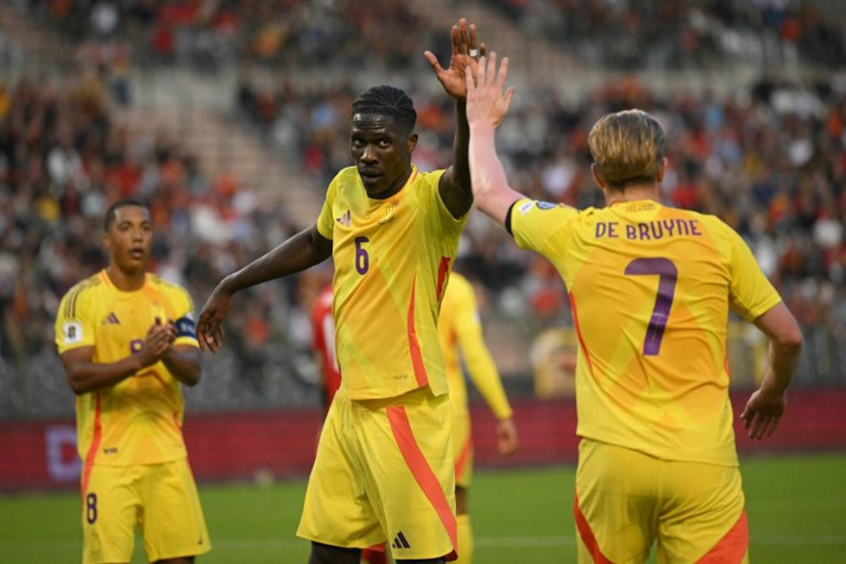 Belgium's midfielder #06 Amadou Onana (C) and Belgium's midfielder #07 Kevin De Bruyne (R) high five each other during the FIFA World Cup 2026 Group J European qualification football match between Belgium and Wales at the King Baudouin Stadium in Brussels, on June 9, 2025.  NICOLAS TUCAT / AFP
