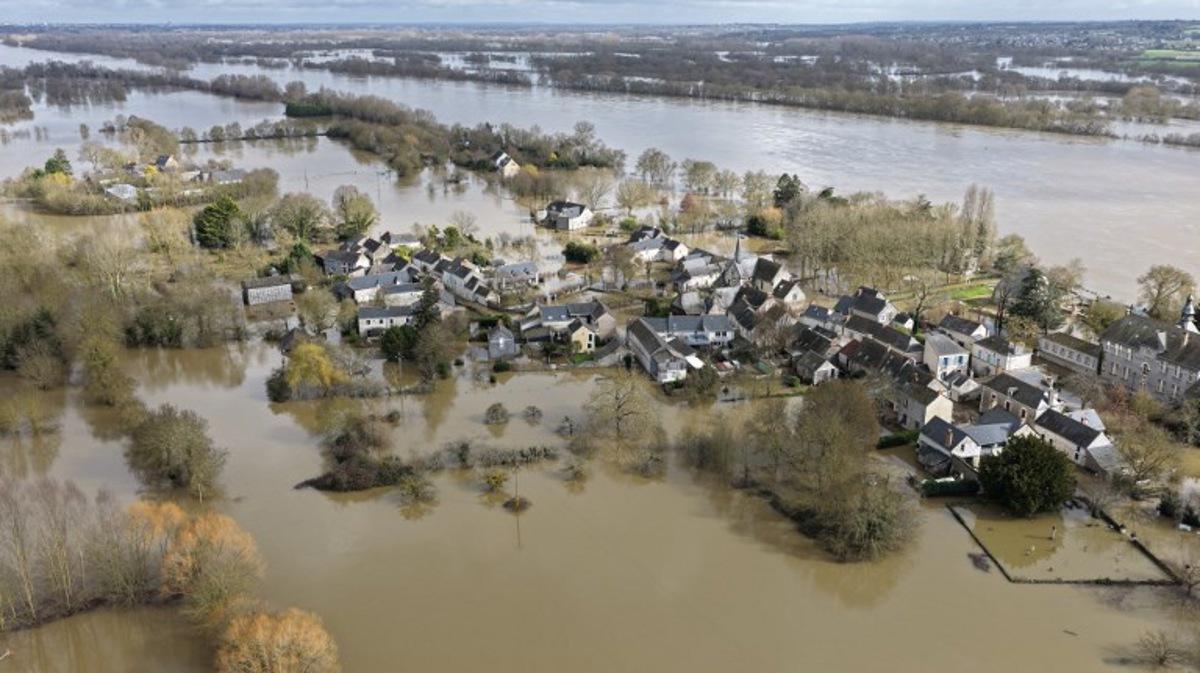 This aerial photograph taken on February 17, 2026, shows the village of Denee submerged by the overflowing Loire River in Denee, western France. The swelling of the Loire River caused a "major flood" on February 17, 2026 near Angers as three departments — Maine-et-Loire, Gironde and Lot-et-Garonne — remain under red alert, the highest warning level. Damien MEYER / AFP
