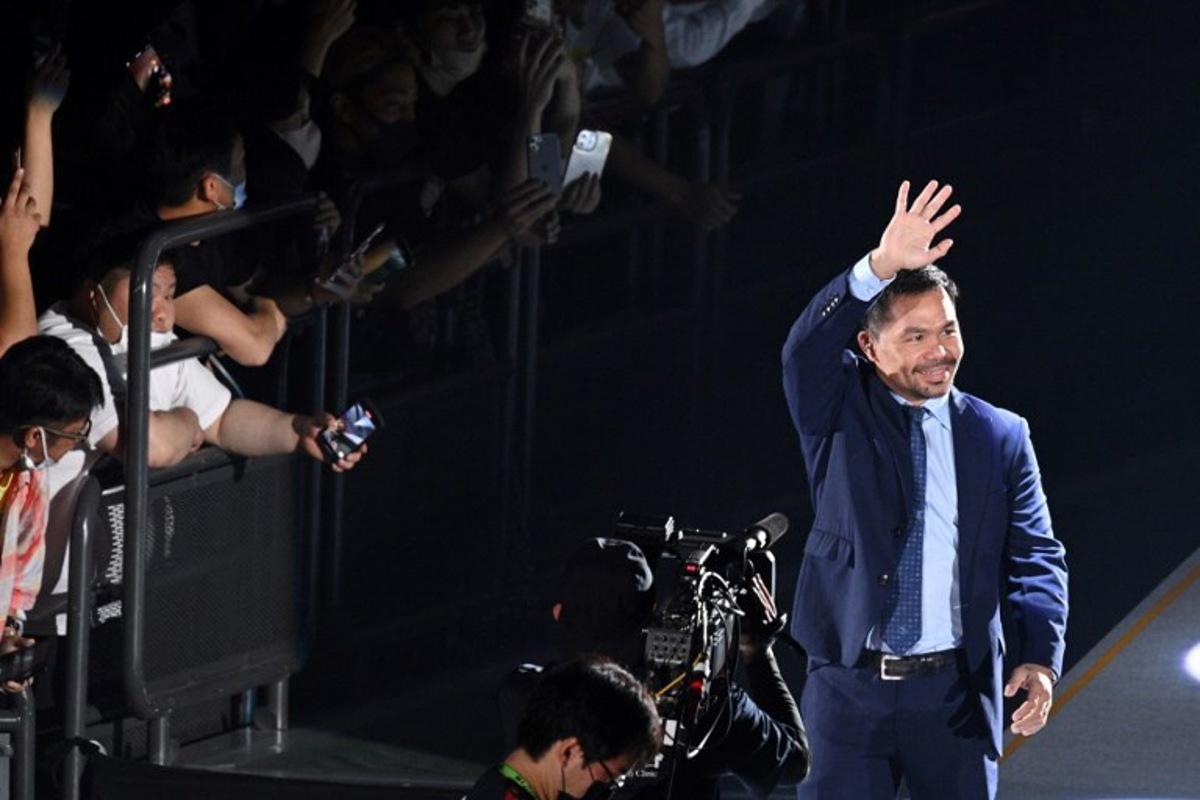 Boxing legend Manny Pacquiao of the Philippines (R) waves as he enters the arena to attend the exhibition match between US boxer Floyd Mayweather and Japanese mixed martial artist Mikuru Asakura at the Saitama Super Arena in Saitama on September 25, 2022.  Philip FONG / AFP