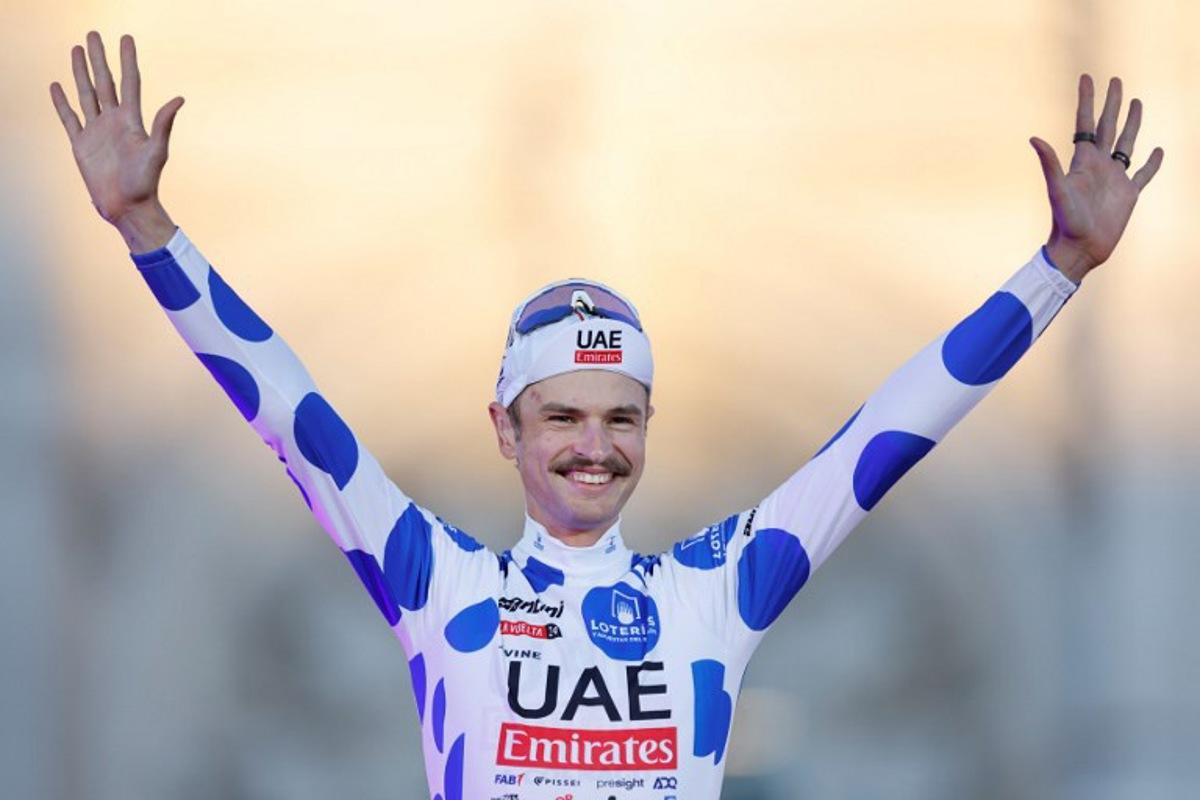 Team UAE's Jay Vine celebrates on the podium wearing the best climber jersey after the last stage of the Vuelta a Espana, a 24,6 km time-trial race between Madrid and Madrid, on September 8, 2024.    OSCAR DEL POZO / AFP
