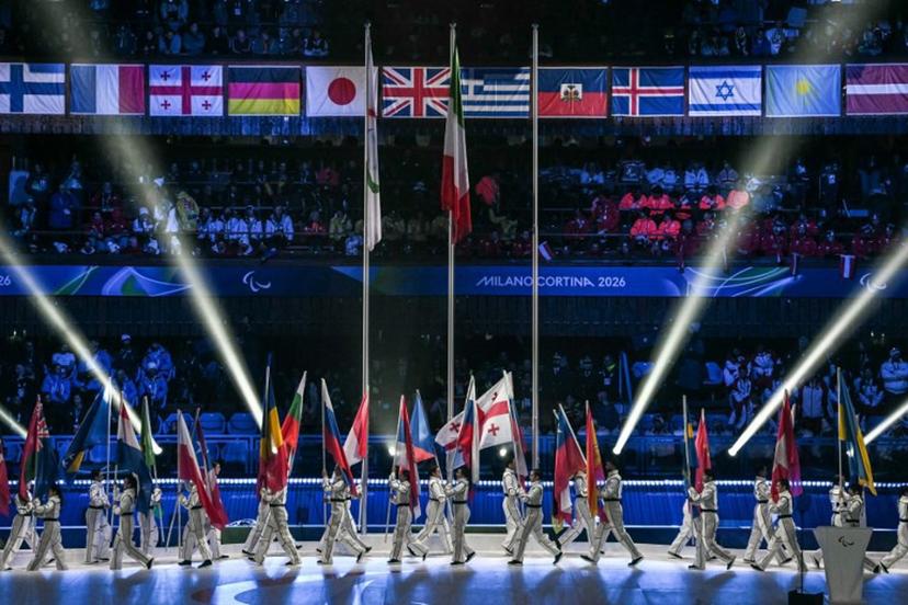 Volunteers parade with flags of countries during the Milano Cortina 2026 Winter Paralympic Games closing ceremony at the Olympic Ice Stadium in Cortina d'Ampezzo, on March 15, 2026.  Jeff PACHOUD / AFP