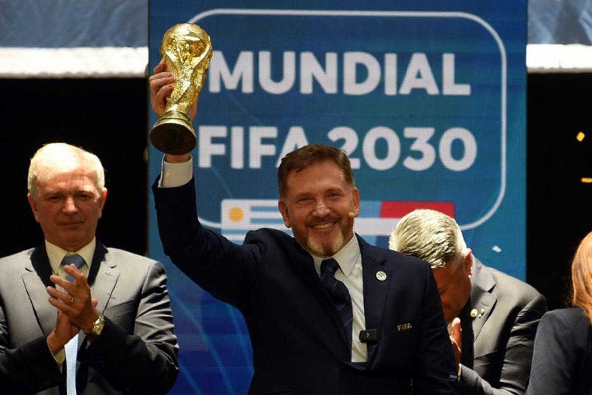 CONMEBOL President Paraguayan Alejandro Dominguez holds a replica of the FIFA World Cup as he celebrates the ratification of Argentina, Paraguay, and Uruguay as host countries of the FIFA 2030 World Cup during the FIFA virtual Congress in Luque, Paraguay, on December 11, 2024. A virtual Congress of world football's governing body confirmed that Morocco, Spain and Portugal will be joint hosts of the 2030 World Cup, which will also see three games played in South America. The 2030 tournament will mark a century since the first World Cup was held in Uruguay, and as a result the unrivalled joint bid by Morocco, Spain and Portugal will also see the South American nation handed one game along with Argentina and Paraguay.  DANIEL DUARTE / AFP