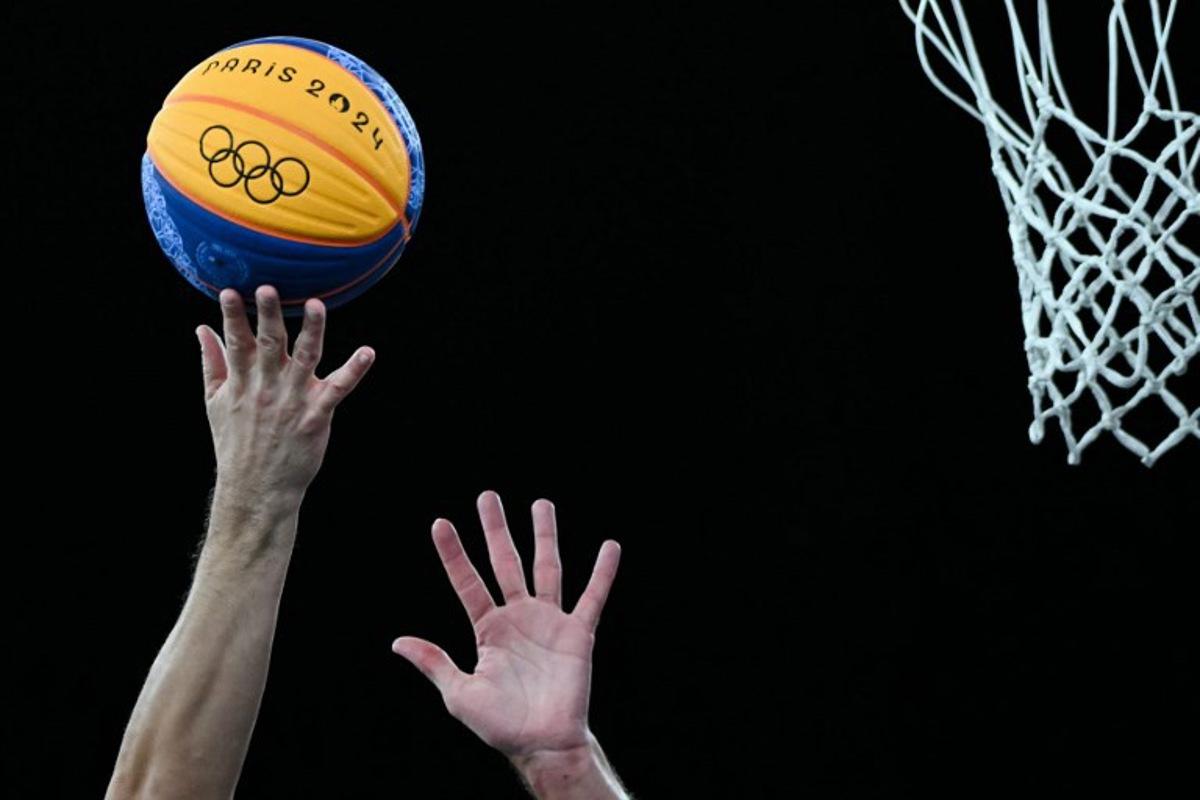 Players try to grab the ball next to the basket in the men's 3x3 basketball play-in games between Serbia and France during the Paris 2024 Olympic Games at La Concorde in Paris on August 4, 2024.  Luis ROBAYO / AFP