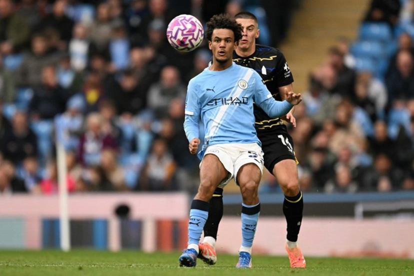 Manchester City's Norwegian midfielder #52 Oscar Bobb battles for the ball with Everton's Ukrainian defender #16 Vitaliy Mykolenko during the English Premier League football match between Manchester City and Everton at the Etihad Stadium in Manchester, north west England, on October 18, 2025.  Oli SCARFF / AFP