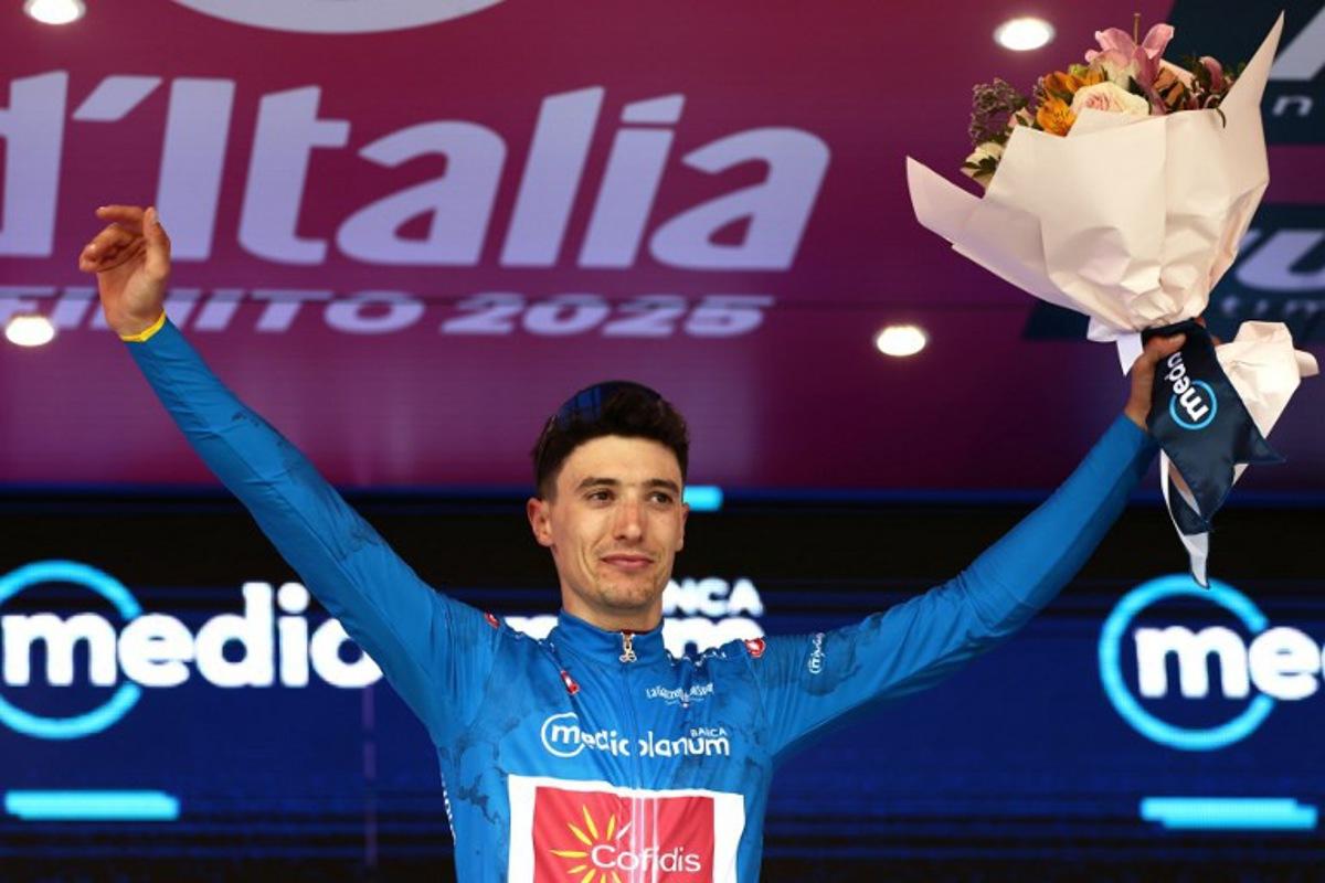 Cofidis' Belgian rider Sylvain Moniquet wears the best climber's blue jersey on the podium after the first stage of the 108th Giro d'Italia cycling race, 160km from Durres to Tirana in Albania, on May 9, 2025.  Luca Bettini / AFP