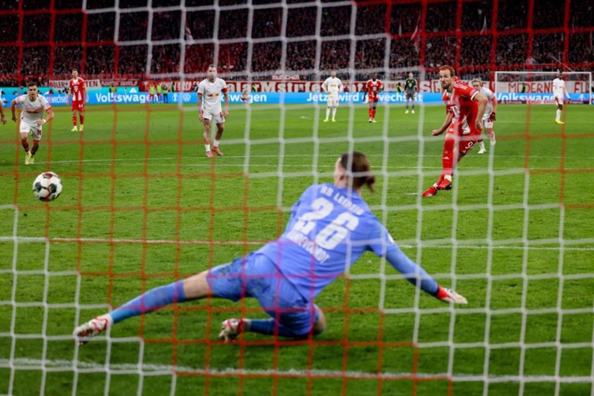 Bayern Munich's English forward #09 Harry Kane (R) scores the opening goal from the penalty spot past Leipzig's Belgian goalkeeper #26 Maarten Vandevoordt during the German Cup (DFB-Pokal) quarter-final football match between FC Bayern Munich and RB Leipzig in Munich, southern Germany on February 11, 2026.  Alexandra BEIER / AFP