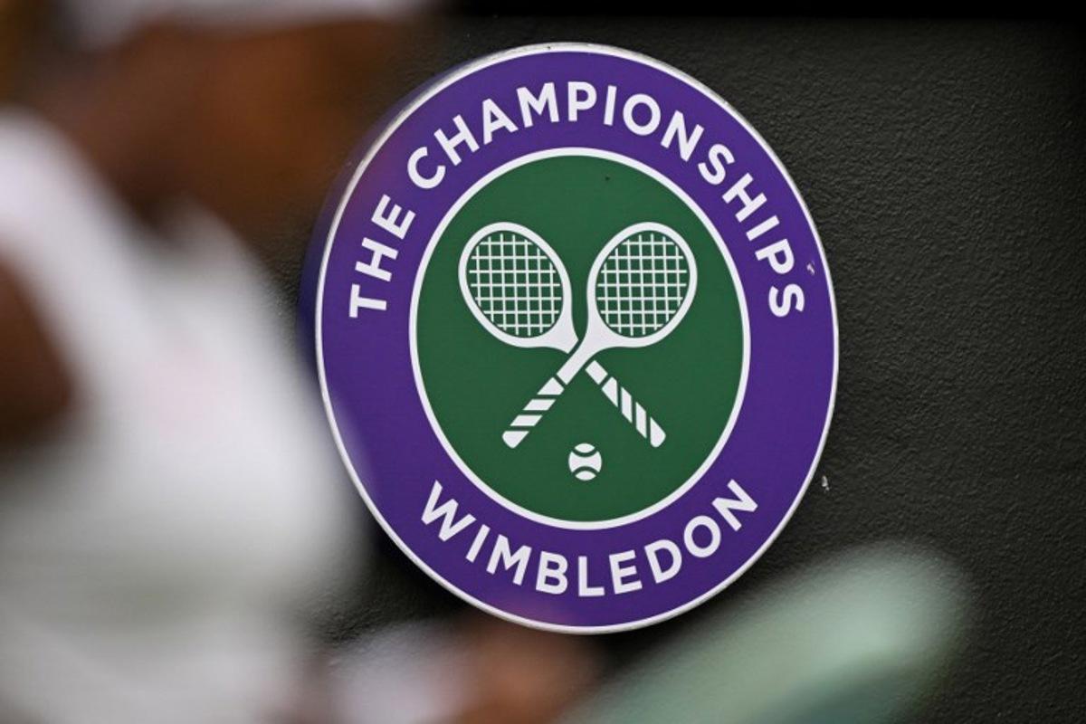 The Wimbledon logo is pictured behind US player Coco Gauff as she arranges the strings of her racket while playing against  Romania's Anca Todoni during their women's singles second round tennis match on the third day of the 2024 Wimbledon Championships at The All England Lawn Tennis and Croquet Club in Wimbledon, southwest London, on July 3, 2024.  ANDREJ ISAKOVIC / AFP