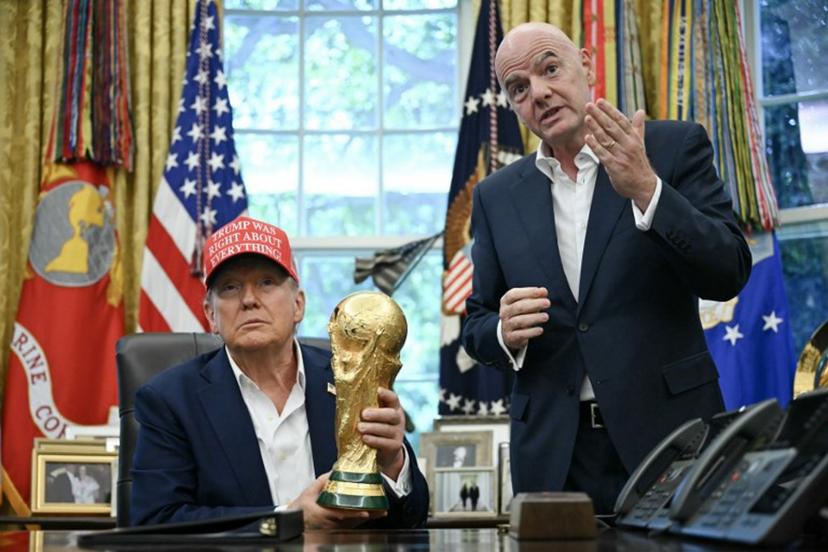 US President Donald Trump joined by FIFA president Gianni Infantino (R) holds the World Cup Trophy as he makes an announcement in the Oval Office of the White House in Washington, DC, on August 22, 2025. Trump announced the 2026 World Cup draw will be held on December 5 at Washington's Kennedy Center. ANDREW CABALLERO-REYNOLDS / AFP