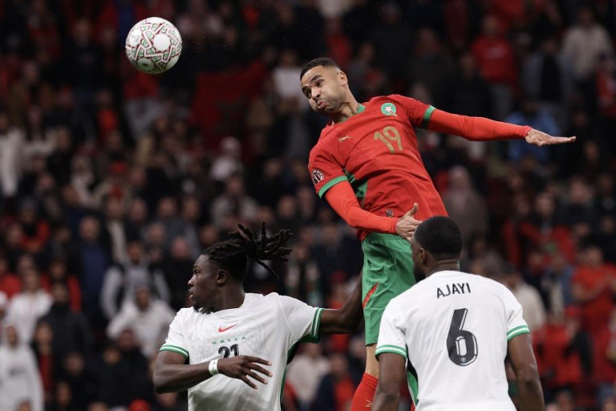Morocco's forward #19 Youssef En-Nesyri jumps to head the ball next to Nigeria's defender #21 Calvin Bassey during the Africa Cup of Nations (CAN) semi-final football match between Nigeria and Morocco at the Prince Moulay Abdellah stadium in Rabat on January 14, 2026.   FRANCK FIFE / AFP