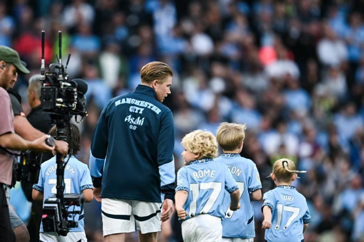 Manchester City's Belgian midfielder #17 Kevin De Bruyne (L) walks on the pitch with his children prior to the English Premier League football match between Manchester City and Bournemouth at the Etihad Stadium in Manchester, north west England, on May 20, 2025.  Paul ELLIS / AFP