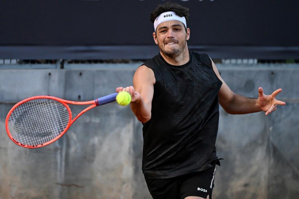 US Taylor Fritz plays a forehand return to Italy's Jannik Sinner during a training session ahead of the ATP Rome Open tennis tournament at Foro Italico in Rome, on May 7, 2025.  PIERO CRUCIATTI / AFP