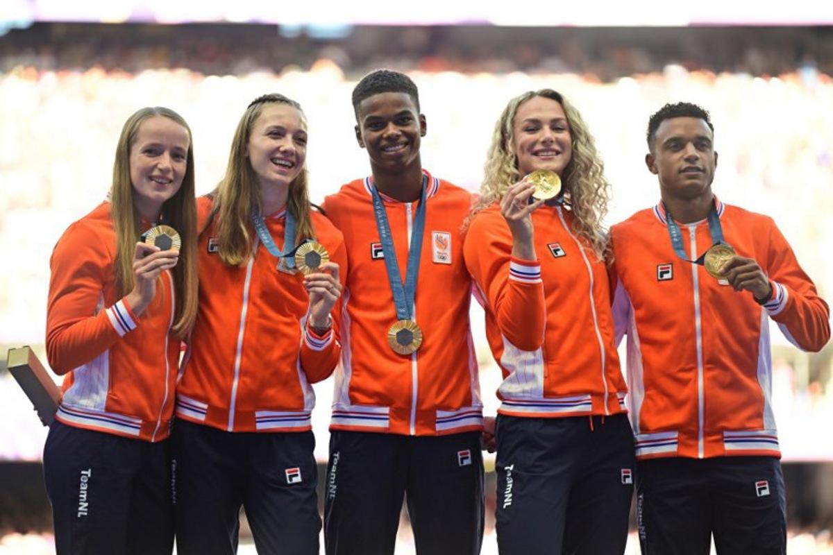 Gold medallists Netherlands' Isaya Klein Ikkink, Eugene Omalla, Lieke Klaver, Femke Bol and Cathelijn Peeters celebrate on the podium after competing in the mixed's 4x400m relay of the athletics event during the Paris 2024 Olympic Games at Stade de France in Saint-Denis, north of Paris, on August 5, 2024.  Martin  BERNETTI / AFP