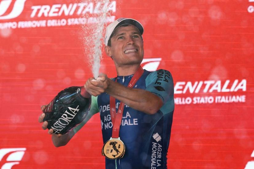 Decathlon AG2R La Mondiale Team's French rider Nicolas Prodhomme sprays champagne as hecelebrates on the podium after victory in the 19th stage of the 108th Giro d'Italia cycling race of 166kms from Biella to Champoluc on May 30, 2025.  Luca Bettini / AFP
