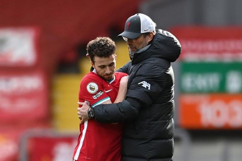 Liverpool's German manager Jurgen Klopp (R) hugs Liverpool's Portuguese striker Diogo Jota at the final whistle during the English Premier League football match between Liverpool and Aston Villa at Anfield in Liverpool, north west England on April 10, 2021.  Laurence Griffiths / POOL / AFP RESTRICTED TO EDITORIAL USE. No use with unauthorized audio, video, data, fixture lists, club/league logos or 'live' services. Online in-match use limited to 120 images. An additional 40 images may be used in extra time. No video emulation. Social media in-match use limited to 120 images. An additional 40 images may be used in extra time. No use in betting publications, games or single club/league/player publications.

