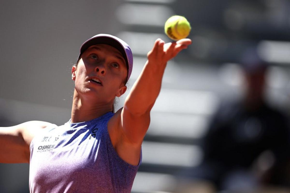 Poland's Iga Swiatek serves to Romania's Jaqueline Cristian during their women's singles match on day 6 of the French Open tennis tournament on Court Suzanne-Lenglen at the Roland-Garros Complex in Paris on May 30, 2025.  Anne-Christine POUJOULAT / AFP