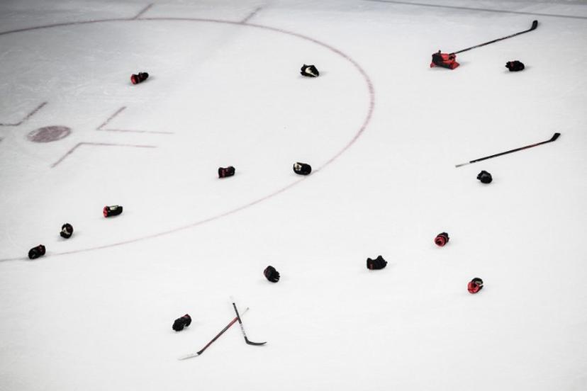Canadian players' gloves and sticks are seen after their victory during the women's gold medal match of the Beijing 2022 Winter Olympic Games ice hockey competition between Canada and USA, at the Wukesong Sports Centre in Beijing on February 17, 2022.  Jeff PACHOUD / AFP