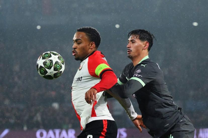 Feyenoord's Dutch midfielder #08 Quinten Timber (L) fights for the ball with AC Milan's Dutch midfielder #14 Tijani Reijnders  during the UEFA Champions League knockout phase play-off 1st leg football match between Feyenoord Rotterdam and AC Milan at the Stadion Feijenoord "De Kuip" in Rotterdam, on February 12, 2025.   JOHN THYS / AFP