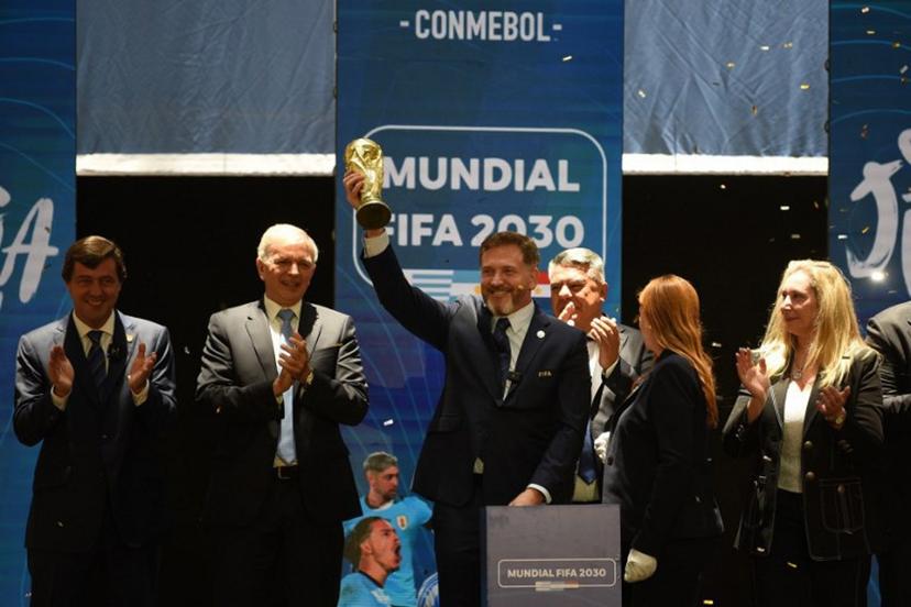 CONMEBOL President Paraguayan Alejandro Dominguez holds a replica of the FIFA World Cup as he celebrates the ratification of Argentina, Paraguay, and Uruguay as host countries of the FIFA 2030 World Cup during the FIFA virtual Congress in Luque, Paraguay, on December 11, 2024. A virtual Congress of world football's governing body confirmed that Morocco, Spain and Portugal will be joint hosts of the 2030 World Cup, which will also see three games played in South America. The 2030 tournament will mark a century since the first World Cup was held in Uruguay, and as a result the unrivalled joint bid by Morocco, Spain and Portugal will also see the South American nation handed one game along with Argentina and Paraguay.  DANIEL DUARTE / AFP