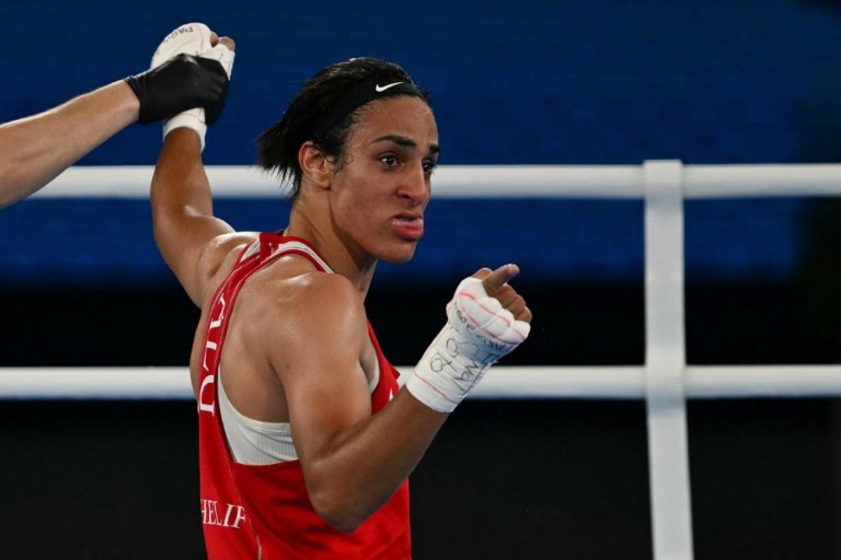 Algeria's Imane Khelif reacts after beating China's Yang Liu (Blue) in the women's 66kg final boxing match during the Paris 2024 Olympic Games at the Roland-Garros Stadium, in Paris on August 9, 2024.  Mauro PIMENTEL / AFP
