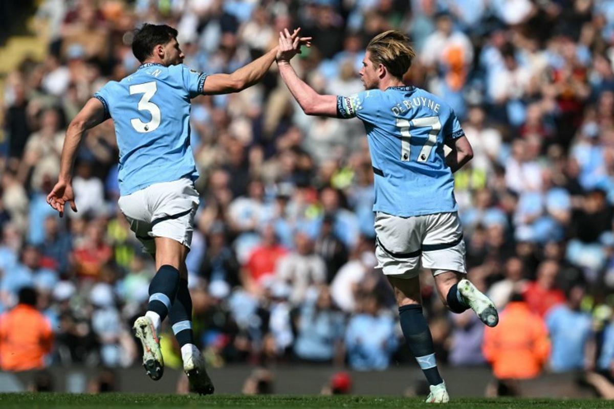 Manchester City's Belgian midfielder #17 Kevin De Bruyne (R) celebrates with Manchester City's Portuguese defender #03 Ruben Dias (L) after scoring their first goal during the English Premier League football match between Manchester City and Crystal Palace at the Etihad Stadium in Manchester, north west England, on April 12, 2025.  Paul ELLIS / AFP