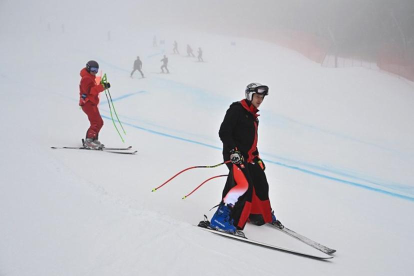 Switzerland's Marco Odermatt (R) inspects the course in the fog before the men's super-G alpine skiing event during the Milano Cortina 2026 Winter Olympic Games at the Stelvio Ski Centre in Bormio (Valtellina) on February 11, 2026.  Fabrice COFFRINI / AFP