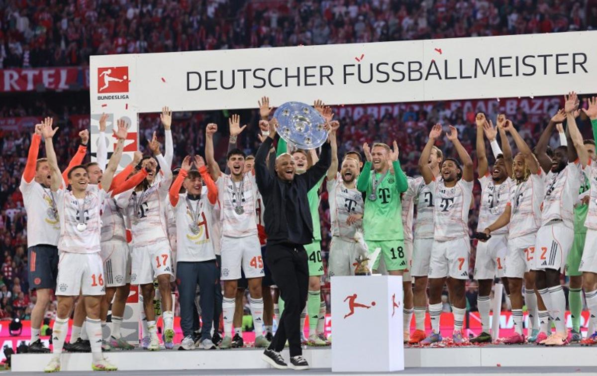 Bayern Munich players celebrate as Bayern Munich's Belgian head coach Vincent Kompany lifts the trophy after the German first division Bundesliga football match between Bayern Munich and Borussia Moenchengladbach in Munich on May 10, 2025.  Alexandra BEIER / AFP