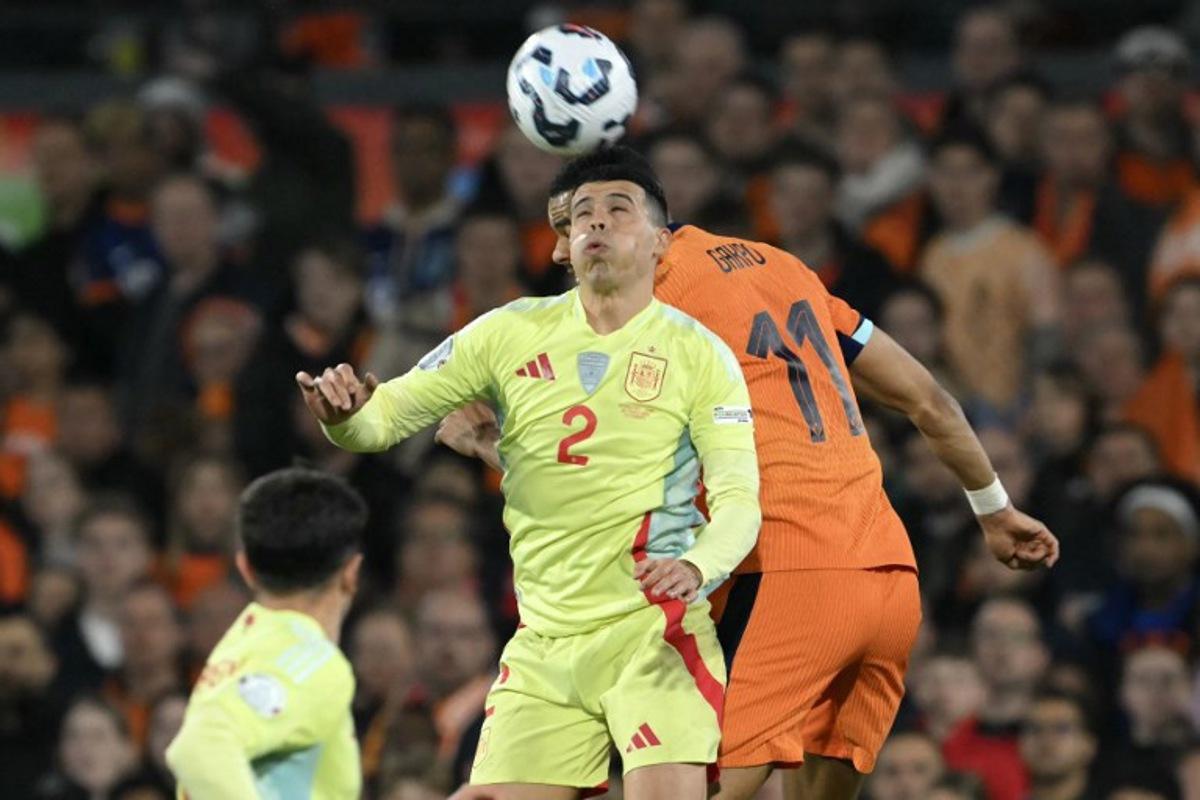 Spain's defender #02 Pedro Porro (L) jumps for the ball during the UEFA Nations League quarter-final first leg match between Netherlands and Spain at De Kuip stadium in Rotterdam, on March 20, 2025.  NICOLAS TUCAT / AFP