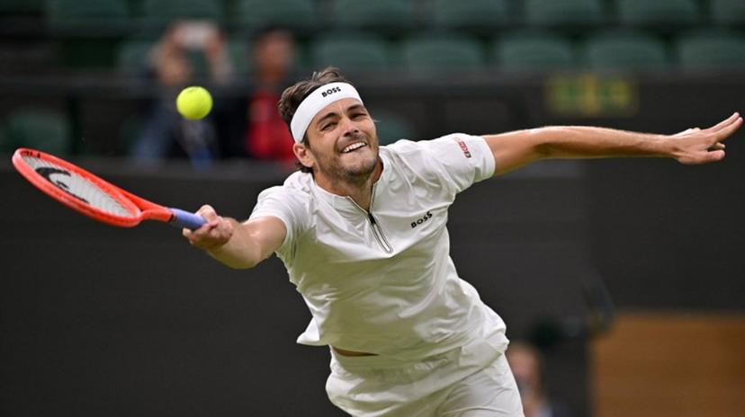 US player Taylor Fritz plays a forehand return to Canada's Gabriel Diallo during their men's singles second round tennis match on the third day of the 2025 Wimbledon Championships at The All England Lawn Tennis and Croquet Club in Wimbledon, southwest London, on July 2, 2025.  Glyn KIRK / AFP