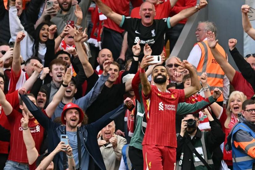 Liverpool's Egyptian striker #11 Mohamed Salah takes a selfie with the fans after scoring their fourth goal during the English Premier League football match between Liverpool and Tottenham Hotspur at Anfield in Liverpool, north west England on April 27, 2025.  Paul ELLIS / AFP