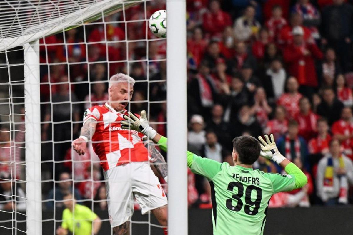 Strasbourg's Belgian goalkeeper #39 Mike Penders (R) and Mainz' German forward #20 Phillip Tietz vie for the ball during the UEFA Europa Conference League quarter-final first leg football match between 1 FSV Mainz 05 and RC Strasbourg Alsace in Mainz, western Germany on April 9, 2026.  Kirill KUDRYAVTSEV / AFP