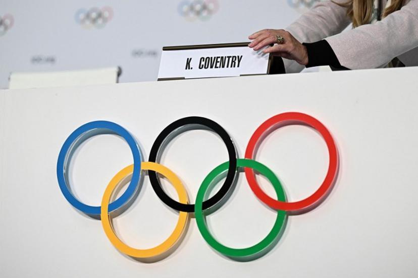 A IOC staff member displays the name of newly-elected Zimbabwean Kirsty Coventry before her press conference as part of the 144th IOC Session on the day of the election of the President of the International Olympic Committee (IOC), in Costa Navarino, Greece on March 20, 2025. Zimbabwe's Kirsty Coventry became the first woman and the first African to be elected president of the International Olympic Committee on March 20, 2025. Fabrice COFFRINI / AFP
