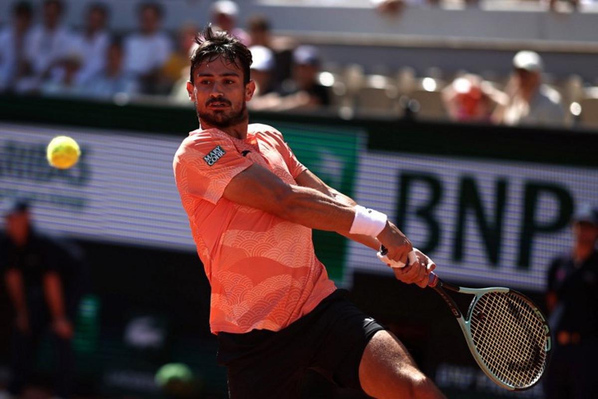 Argentina's Mariano Navone plays a backhand return to Italy's Lorenzo Musetti during their men's singles match on day 6 of the French Open tennis tournament on Court Suzanne-Lenglen at the Roland-Garros Complex in Paris on May 30, 2025.  Anne-Christine POUJOULAT / AFP