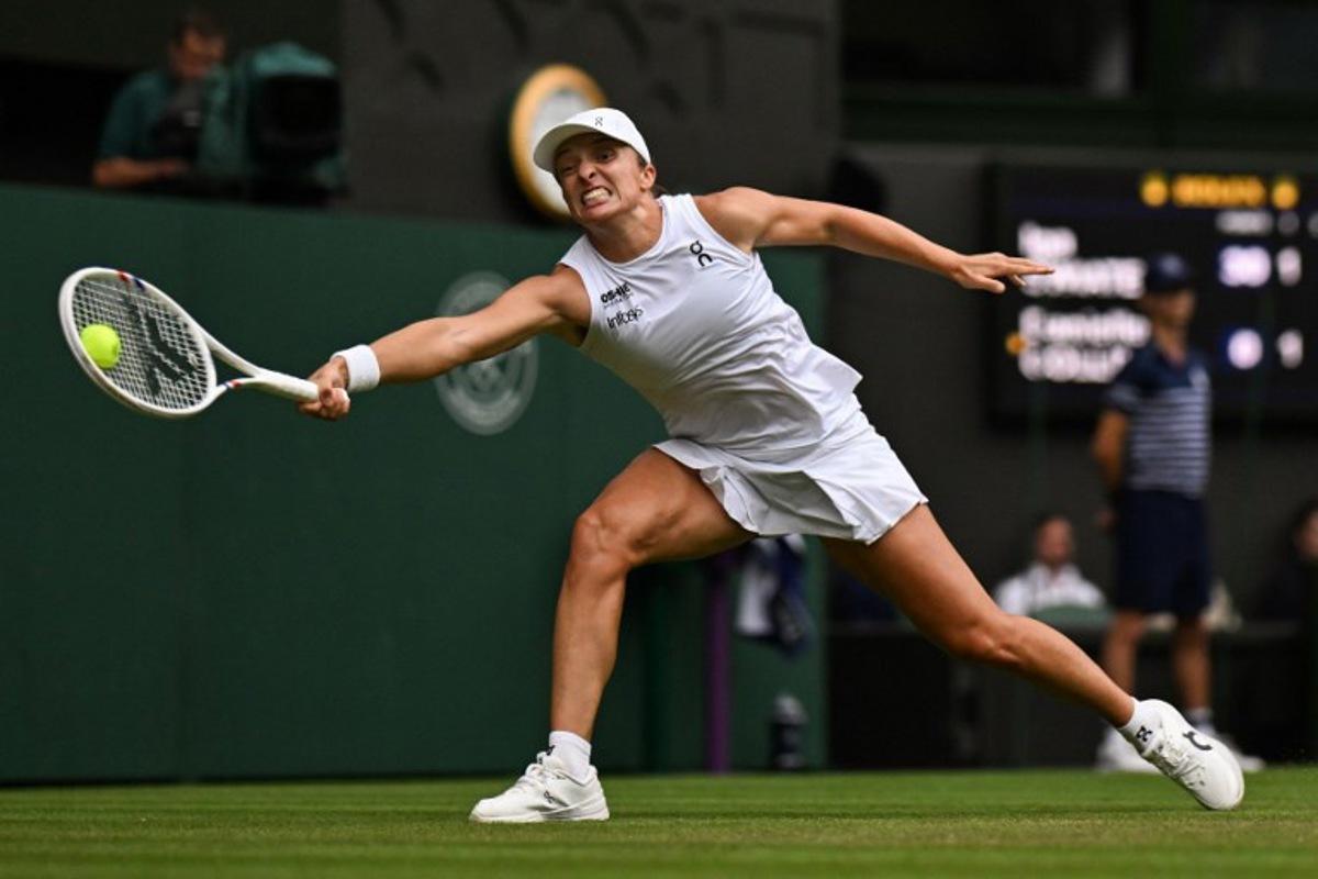 Poland's Iga Swiatek plays a forehand return to US player Danielle Collins during their women's singles third round tennis match on the sixth day of the 2025 Wimbledon Championships at The All England Lawn Tennis and Croquet Club in Wimbledon, southwest London, on July 5, 2025.  Glyn KIRK / AFP