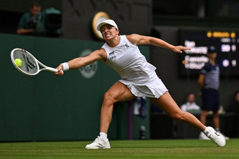 Poland's Iga Swiatek plays a forehand return to US player Danielle Collins during their women's singles third round tennis match on the sixth day of the 2025 Wimbledon Championships at The All England Lawn Tennis and Croquet Club in Wimbledon, southwest London, on July 5, 2025.  Glyn KIRK / AFP