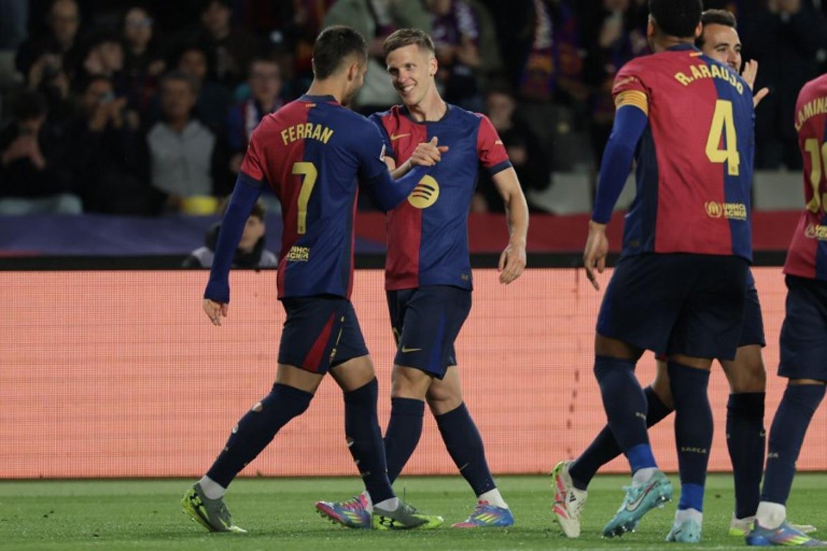 Barcelona's Spanish forward #20 Daniel Olmo (2L) celebrates with teammates after scoring his team's first goal during the Spanish league football match between FC Barcelona and RCD Mallorca at the Estadi Olimpic Lluis Companys in Barcelona, on April 22, 2025.  LLUIS GENE / AFP