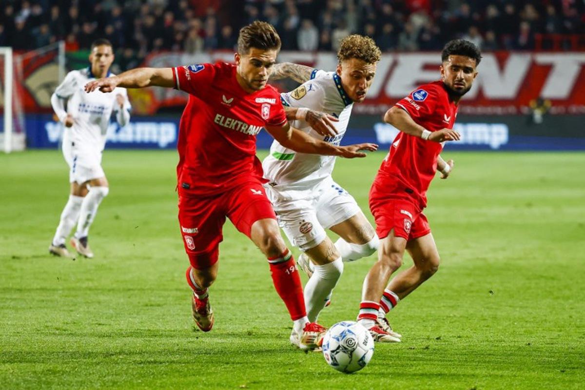 PSV's Dutch forward #07 Noa lang (C) fights for the ball with FC Twente's Dutch defender #28 Bart van Rooij (2L) during the Dutch Eredivisie football match between FC Twente and PSV Eindhoven at the Stadion De Grolsch Veste, in Enschede, on April 24, 2025.  Vincent Jannink / ANP / AFP