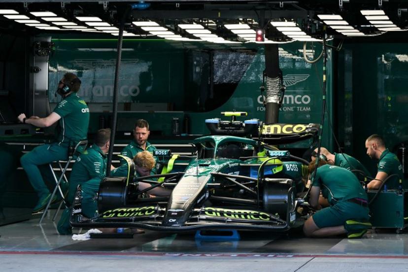 Aston Martin crew members work on the car of Aston Martin's Spanish driver Fernando Alonso ahead of the practice session for the United States Formula One Grand Prix at the Circuit of the Americas in Austin, Texas, on October 17, 2025.  RONALDO SCHEMIDT / AFP