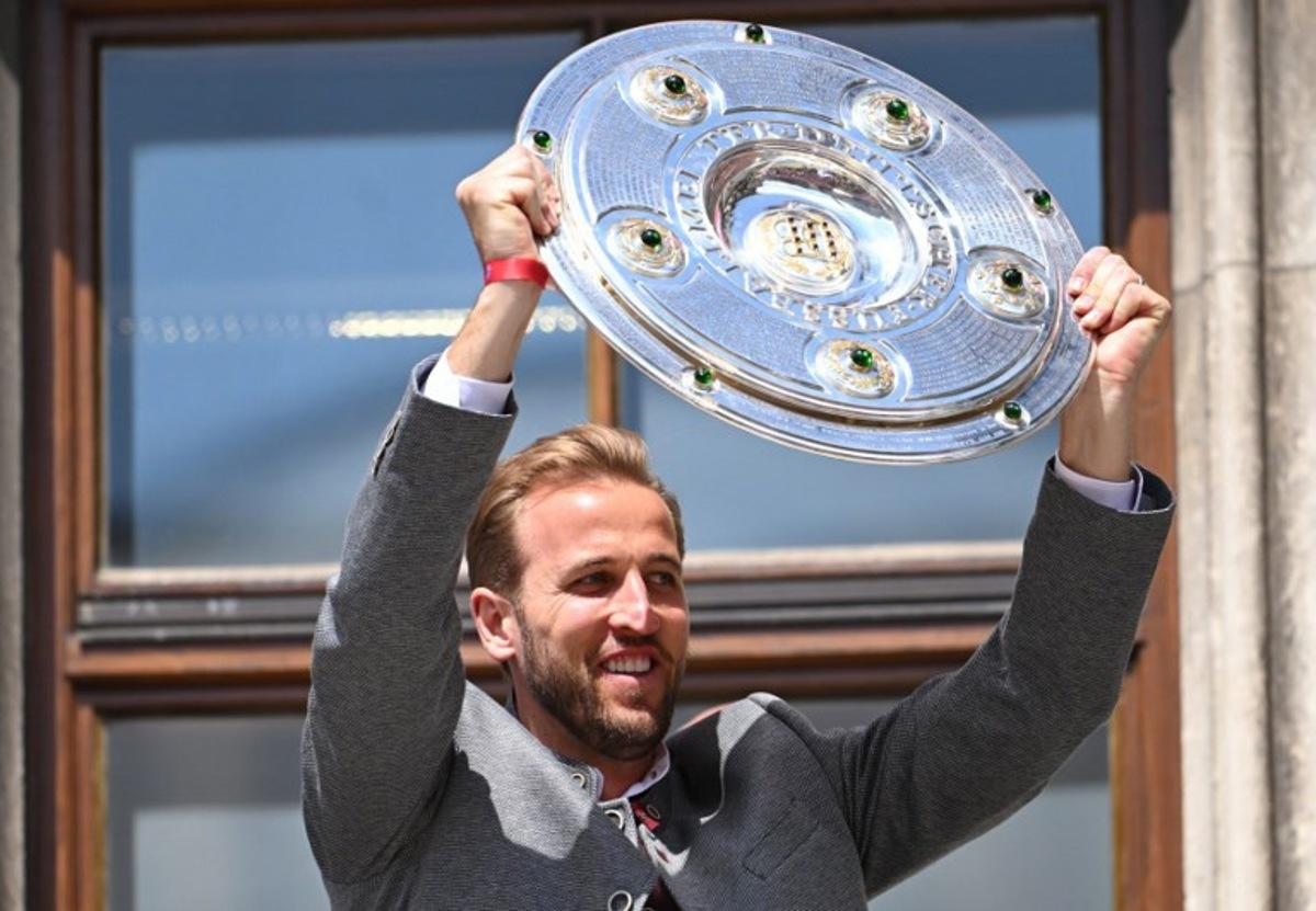 Bayern Munich's English forward #09 Harry Kane celebrates with the trophy on the balcony at the City Hall at Marienplatz in Munich, southern Germany, on May 18, 2025. The men's and women's teams of FC Bayern Munich both celebrate their Bundesliga championship titles. Bayern Munich's women also celebrate winning the DFB Cup. LUKAS BARTH-TUTTAS / AFP