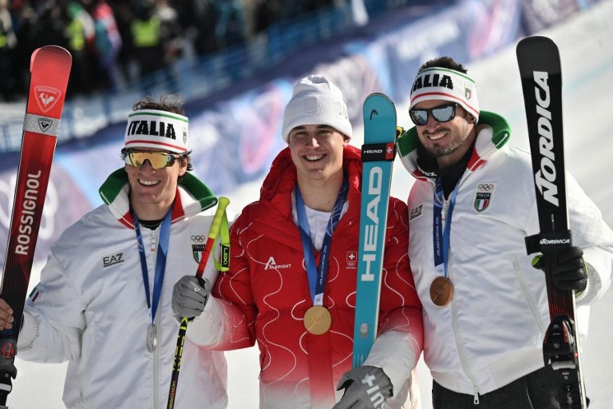 Gold medallist Switzerland's Franjo von Allmen (C), silver medallist Italy's Giovanni Franzoni (L) and bronze medallist Italy's Dominik Paris (R) pose after the men's downhill alpine skiing event during the Milano Cortina 2026 Winter Olympic Games at the Stelvio Ski Centre in Bormio (Valtellina) on February 7, 2026.   Jeff PACHOUD / AFP