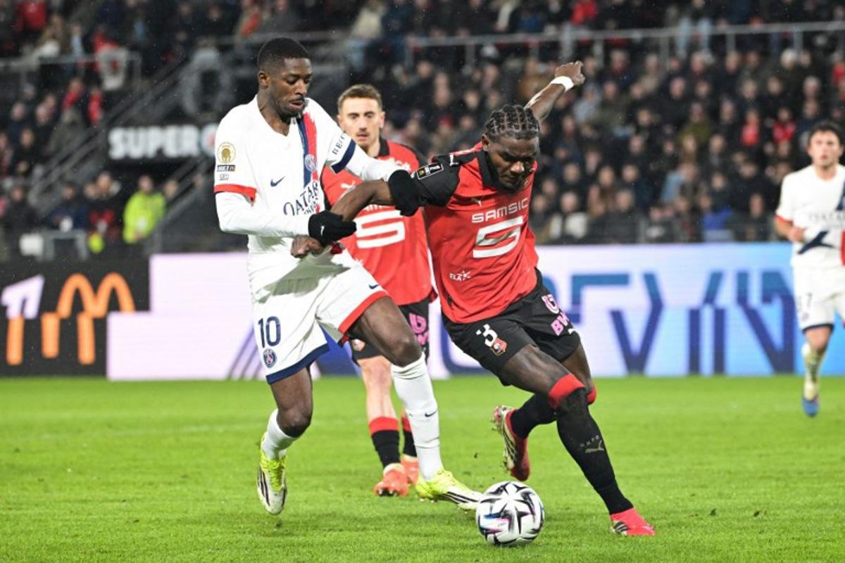 Paris Saint-Germain's French forward #10 Ousmane Dembele (L) and Rennes' French defender #03 Lilian Brassier (R) fight for the ball during the French L1 football match between Stade Rennais FC and Paris Saint-Germain (PSG) at the Roazhon Park stadium in Rennes, western France, on February 13, 2026.  Damien MEYER / AFP