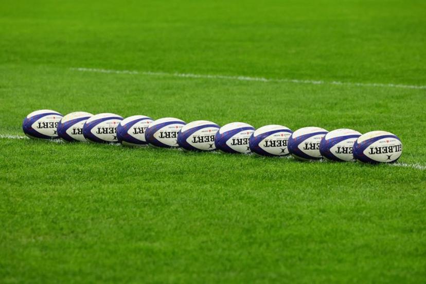 This photograph taken on February 2, 2024 in Marseille, south-eastern France, shows Gilbert match rugby balls lined up on the pitch at the Stade Velodrome ahead of the Six Nations international rugby union match between France and Ireland.  CLEMENT MAHOUDEAU / AFP