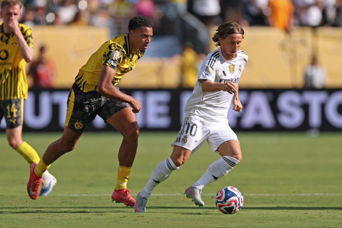 Guest, Borussia Dortmund's German midfielder #08 Felix Nmecha (L) fights for the ball with Real Madrid's Croatian midfielder #10 Luka Modric during the FIFA Club World Cup 2025 quarterfinal football match between Spain's Real Madrid and Germany's Borussia Dortmund at the MetLife stadium in East Rutherford, New Jersey on July 5, 2025.  CHARLY TRIBALLEAU / AFP