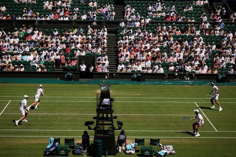 Australia's Rinky Hijikata playing with Netherlands' David Pel (R) return the ball to Britain's Julian Cash and Britain's Lloyd Glasspool (L) during their men's doubles final tennis match on the thirteenth day of the 2025 Wimbledon Championships at The All England Lawn Tennis and Croquet Club in Wimbledon, southwest London, on July 12, 2025.  HENRY NICHOLLS / AFP