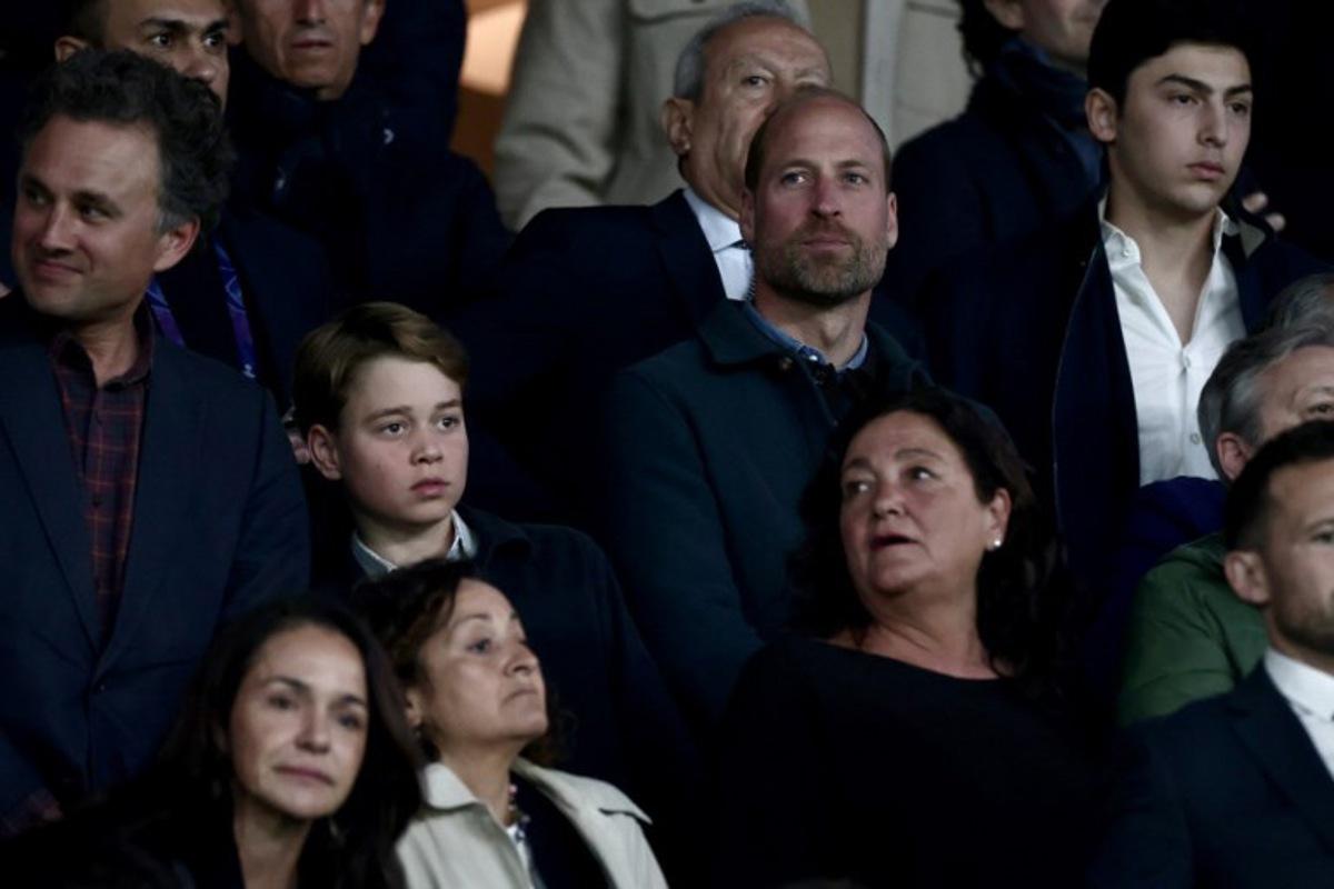 Britain's Prince William, Prince of Wales (CR) and his son Britain's Prince George of Wales (CL) look on from the stands ahead of the UEFA Champions League Quarter final first leg football match between Paris Saint-Germain (FRA) and Aston Villa (ENG) at the Parc des Princes stadium in Paris on April 9, 2025.  Thibaud MORITZ / AFP