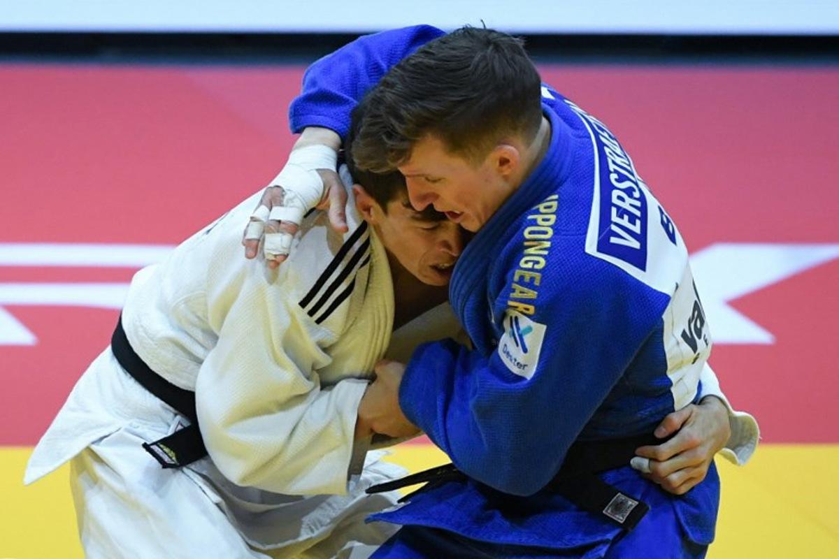 Turkmenistan's Aybek Omirov fights against Belgium's Jorre Verstraeten (blue) in the men's -60kg qualification round bout of the Judo World Championships at the Papp Laszlo Arena in Budapest, Hungary on June 13, 2025.  Ferenc ISZA / AFP