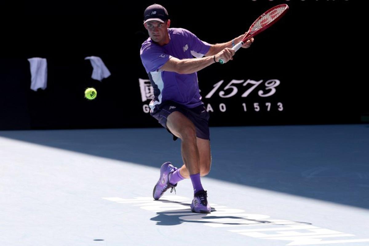 USA's Tommy Paul hits a return to Spain's Carlos Alcaraz during their men's singles match on day eight of the Australian Open tennis tournament in Melbourne on January 25, 2026.   DAVID GRAY / AFP