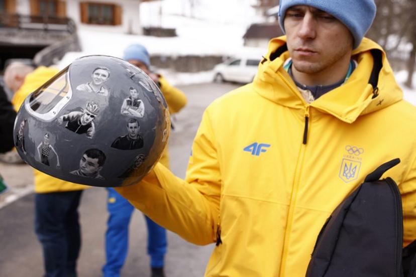 Ukraine's skeleton racer Vladyslav Heraskevych holds his helmet, which depicts victims of his country's war with Russia, in Cortina d'Ampezzo on February 12, 2026. Heraskevych was disqualified from the Winter Olympics on February 12, 2026 after refusing to back down over his banned helmet, which depicts victims of his country's war with Russia. The International Olympic Committee said he had been kicked out of the Milan-Cortina Games "after refusing to adhere to the IOC athlete expression guidelines". Odd ANDERSEN / AFP