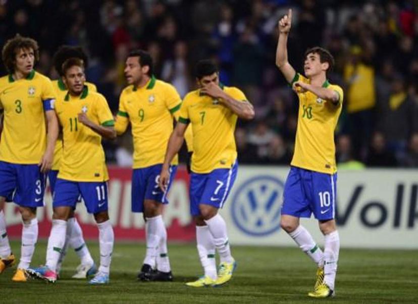 Brazilian midfielder Oscar (R) celebrates with teammates after scoring during the FIFA World Cup exhibition match between Italy and Brasil, March 21, 2012, at the stadium of Geneva . AFP PHOTO / FABRICE COFFRINI
