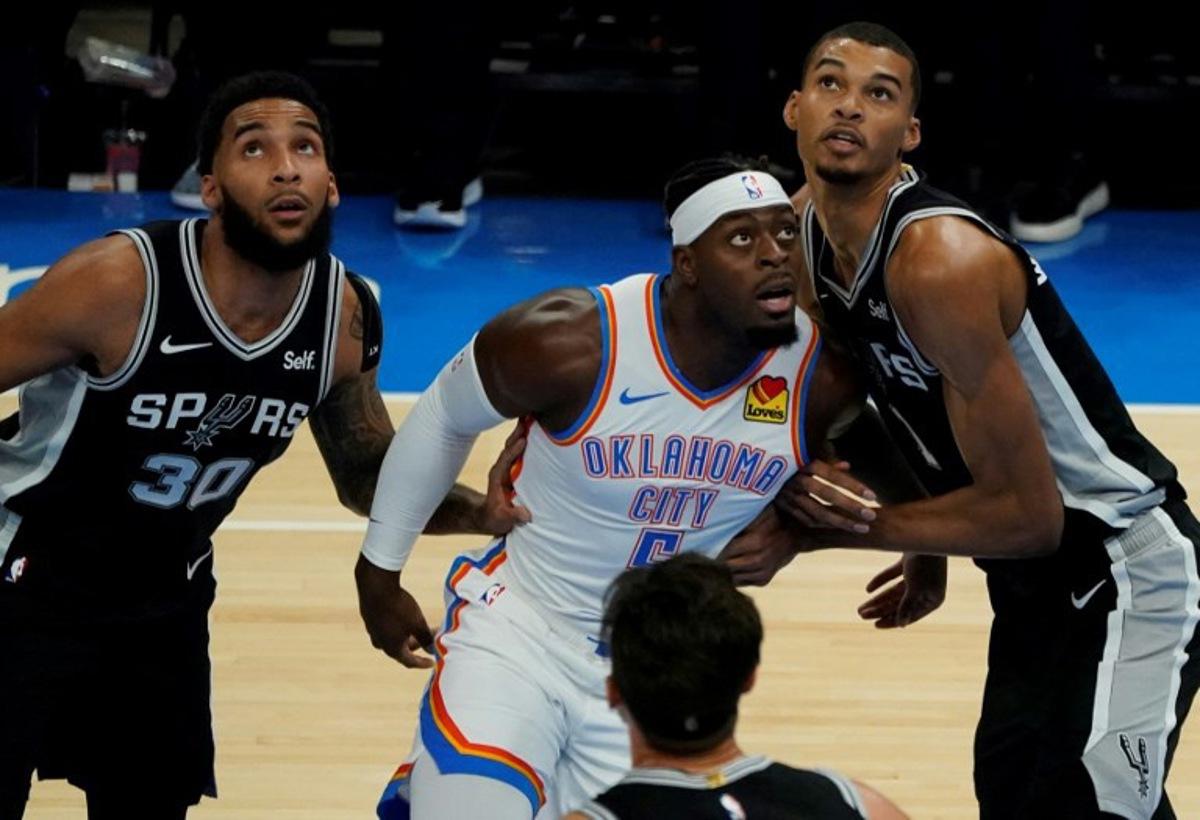 San Antonio Spurs US forward #30 Julian Champagnie, San Antonio Spurs US power forward #23 Zach Collins, and San Antonio Spurs French center #01 Victor Wembanyama defend against Oklahoma City Thunder's Canadian guard #05 Luguentz Dort during the NBA pre-season basketball game between San Antonio Spurs and Oklahoma City Thunder at Paycom Center arena in Oklahoma City, Oklahoma, on October 9, 2023.  TIMOTHY A. CLARY / AFP